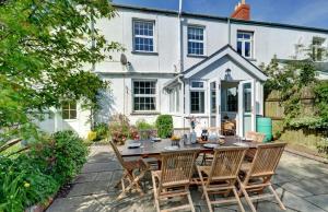 a patio with a table and chairs in front of a house at 4 Bed in Parracombe oc-laurel in Parracombe