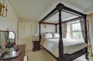 a bedroom with a canopy bed and a table at 4 Bed in Parracombe oc-laurel in Parracombe