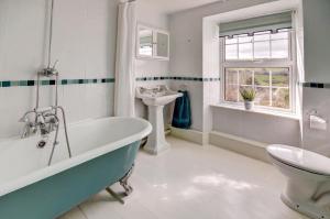 a bathroom with a tub and a sink and a toilet at 4 Bed in Parracombe oc-laurel in Parracombe +20 photos