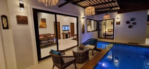 a swimming pool with chairs and a table next to a house at Sila Thai Pool Villa3 in Ao Nang Beach