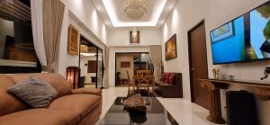 a living room with a couch and a flat screen tv at Sila Thai Pool Villa3 in Ao Nang Beach +20 photos