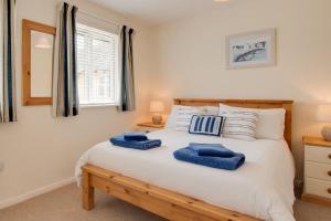 a bedroom with a white bed with blue towels on it at 2 Bed in Instow oc-stones in Instow