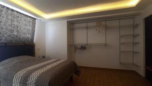 a bedroom with a bed and shelves in a room at Casa Terraza Oaxaca in San Sebastián Etla