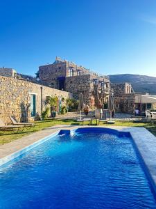 a swimming pool in front of a stone building at FİNTOZ BUTİKA New in Karaburun