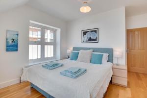 a bedroom with a bed with two towels on it at 1 Bed in Woolacombe oc-seablu in Woolacombe