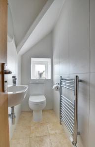 a white bathroom with a toilet and a sink at 1 Bed in Woolacombe oc-seablu in Woolacombe +9 photos