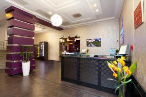 a lobby of a restaurant with a counter and flowers at Hotel Pegas in Krasnodar