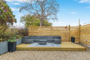 a backyard patio with a fire pit and a wooden deck at 1 Bed in Ashcott oc-m33651 in Ashcott