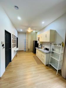 a kitchen with white cabinets and a wooden floor at Desa Ibol Cottage and River - Max 10Pax in Kampong Sumpitan