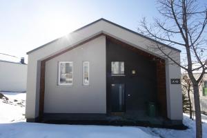 a small house with a black door in the snow at Aeris Residence Panoramic View in Sarajevo +42 photos
