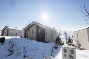 a building with snow on the ground in front of it at Aeris Residence Panoramic View in Sarajevo