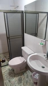 a bathroom with a toilet and a sink at Hotel Casa Franco in Cali