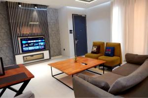 a living room with a couch and a table and a tv at 2020 Apartment Katampe in Mama