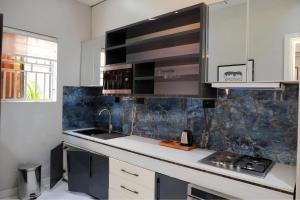 a kitchen with black and white cabinets and a sink at 2020 Apartment Katampe in Mama