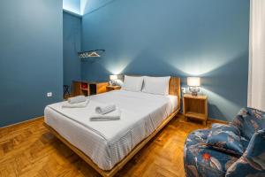 a bedroom with a large bed and a chair at Iliotropio Athens, Thisio in Athens