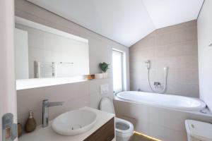 a bathroom with a tub and a toilet and a sink at Aeris Residence Panoramic View in Sarajevo