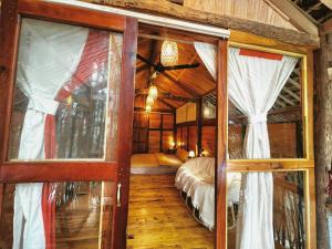 a room with a bedroom with a bed and windows at Napong Ecolodge in Lung Co (1)