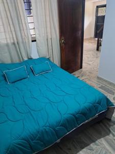 a bed with blue sheets and pillows in a room at Hotel Casa Franco in Cali +4 photos