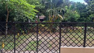 a black fence in front of a dirt road at Hotel Casa Franco in Cali