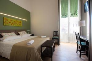 a bedroom with a bed and a desk and a window at Cianciana in Catania