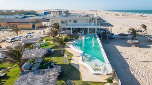 an aerial view of a house with a swimming pool and the beach at Positano Village in Canoa Quebrada