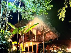 a bamboo house with a thatched roof at night at Napong Ecolodge in Lung Co (1)