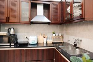 a kitchen with wooden cabinets and a sink at Toda House - 4Bedroom near Hoan Kiem Lake in Hanoi