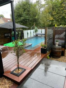 a wooden deck with a pool in a backyard at Apartment Design Suite in Jehanster