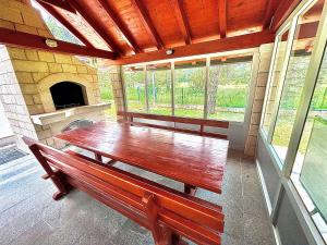 a large wooden table in a room with windows at Calm Stay Blidinje in Blidinje