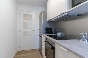 a kitchen with a counter top and a door at Hauzify I Apartament Pedrera in Tarragona +16 photos