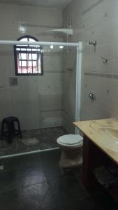 a bathroom with a toilet and a glass shower at casa de praia grande e espaçosa in Bertioga +11 photos