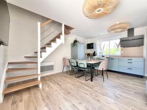 a kitchen and dining room with a staircase and a table at Le Petit Héros Gîte in Courlay