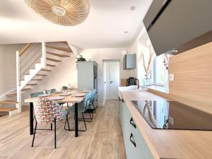 a kitchen and dining room with a table and a staircase at Le Petit Héros Gîte in Courlay +6 photos
