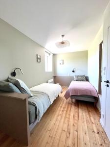 a bedroom with a large bed and a wooden floor at Le Petit Héros Gîte in Courlay