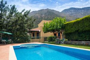 a swimming pool in front of a house with mountains at Villa Apelia - Family Holidays Deals in Vlikhádha