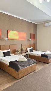 two beds in a room with two beds sidx sidx sidx at Caravan Hotel in Karakol