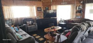 a living room with couches and a flat screen tv at Buffelslaagte at the Vaal in Oranjeville