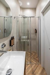 a bathroom with a shower and a white sink at Iliotropio Athens, Thisio in Athens