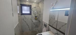 a bathroom with a shower and a toilet and a window at DaRo-Appartments in Asprovalta +11 photos