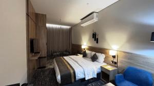 a bedroom with a bed and a blue chair at فندق حياة بارك المدينة in Medina +36 photos
