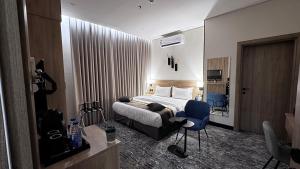 a hotel room with a bed and a blue chair at فندق حياة بارك المدينة in Medina