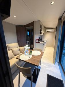 a dining room and kitchen with a table and a couch at La Tiny de la chicorée in Paulhan