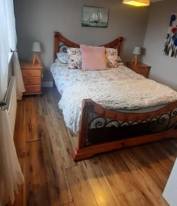 a bedroom with a bed with a wooden floor at Island View Lodge in Doolin