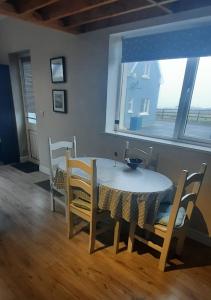 a dining room table and chairs with a table and a window at Island View Lodge in Doolin +3 photos
