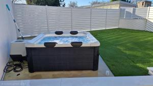 a hot tub sitting on top of a yard at Le Petit Héros Gîte in Courlay