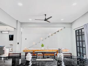 a living room with a table and a ceiling fan at Casa Solaje in Brisas de Zicatela