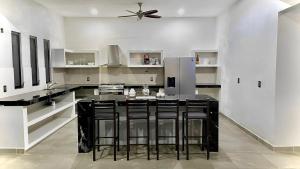 a kitchen with a black island in the middle at Casa Solaje in Brisas de Zicatela
