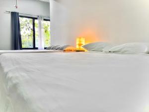 a white bed in a room with a window at Casa Solaje in Brisas de Zicatela