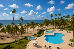 an aerial view of a resort with two pools and palm trees at Stunning Beachfront 2BR Condo in Juan Dolio in Juan Dolio