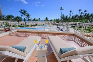 a patio with a table and chairs and a pool at Stunning Beachfront 2BR Condo in Juan Dolio in Juan Dolio